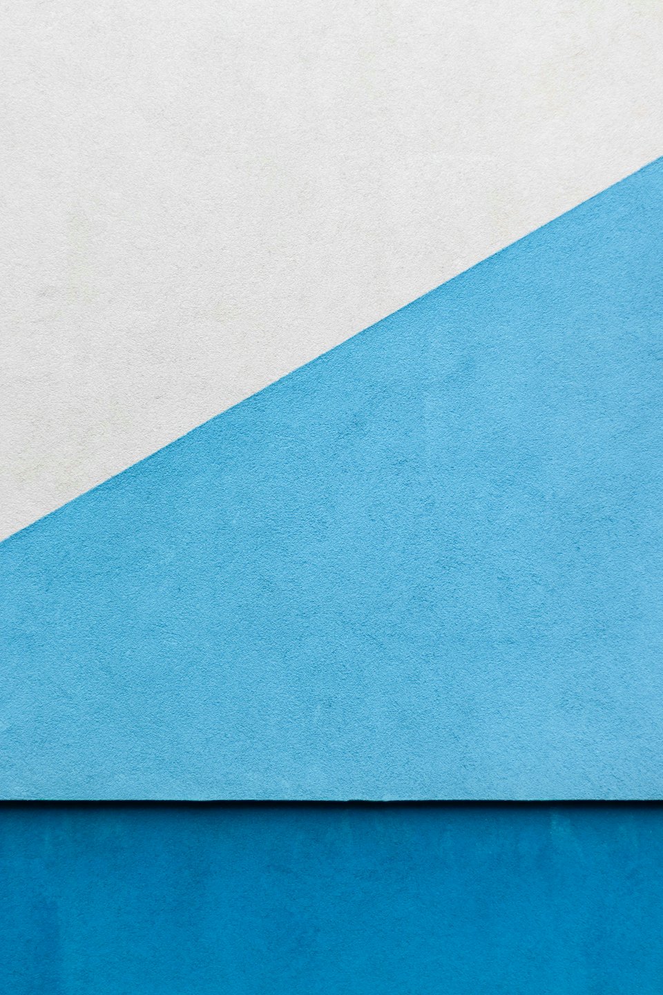 Geometrische Formen bilden ein strukturiertes abstraktes Muster aus bemalten Wänden.
